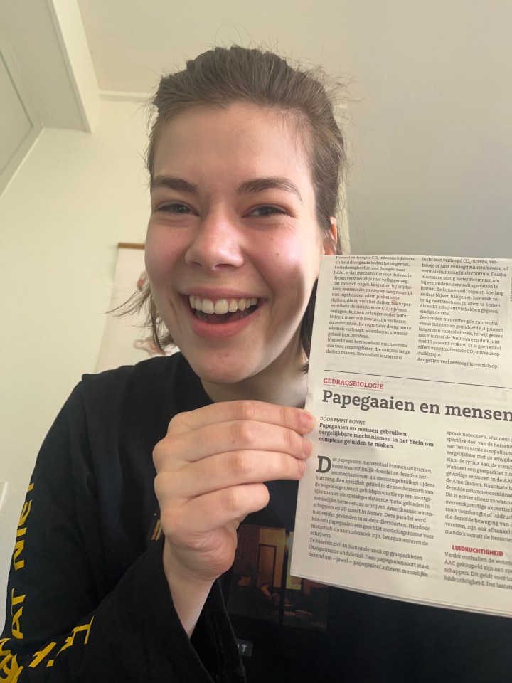 On the picture you see a happy Marit together with her first BioNieuws article on the similarites of the parrot and human brain